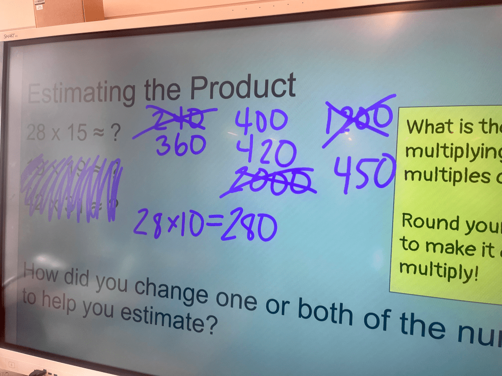 A smartboard showing the problem 28 x 15, and a series of student estimates:
260
400
420
450

and crossed out: 240, 2000, 1200